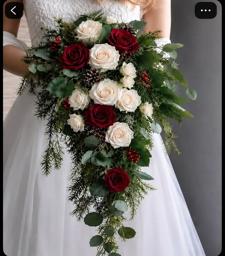 Bouquet a cascata di rose rosse e bianche con verde di conifera